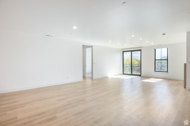 unfurnished room with recessed lighting, light wood-type flooring, and baseboards