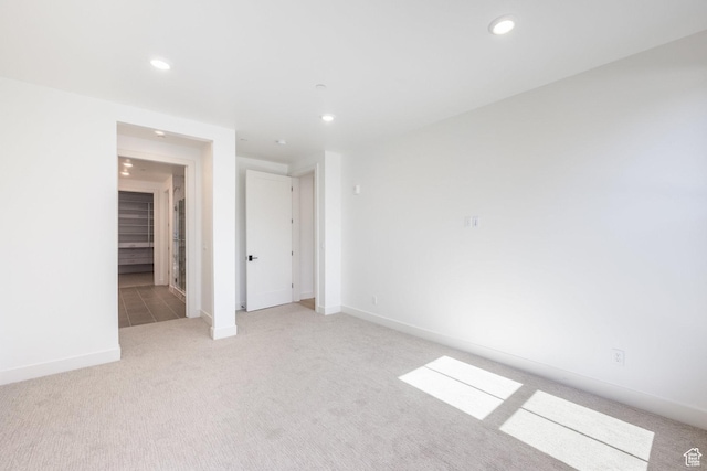 unfurnished room featuring recessed lighting, baseboards, and light carpet