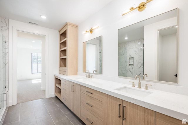bathroom featuring a sink, a marble finish shower, visible vents, and tile patterned floors