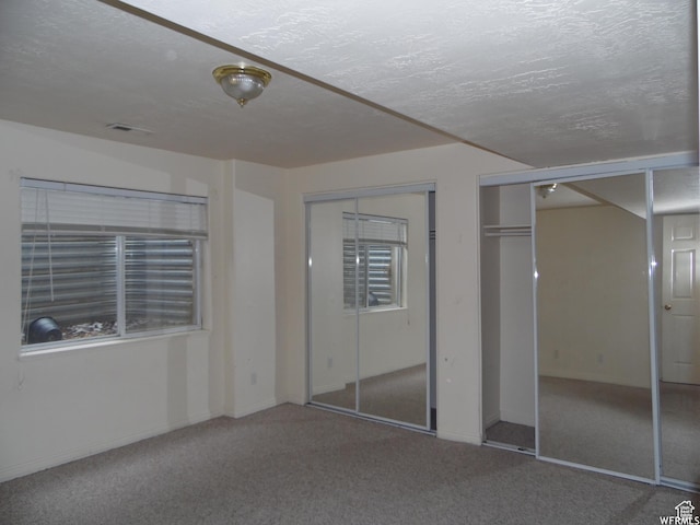 14028 S Candy Pull Dr, Draper, UT 84020 - unfurnished bedroom featuring multiple closets, visible vents, carpet, and a textured ceiling