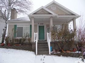 view of front of property with a chimney and covered porch