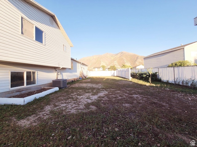 view of yard featuring a fenced backyard, a mountain view, and cooling unit