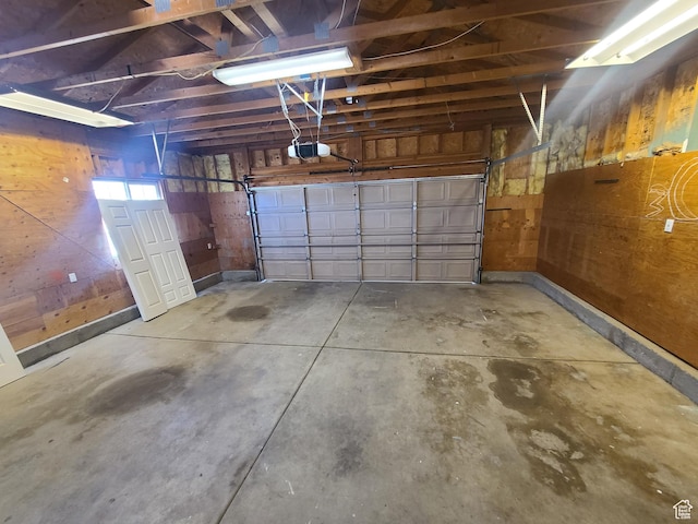 garage featuring wooden walls and a garage door opener