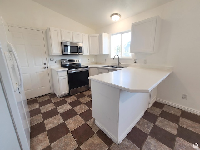 kitchen with a sink, lofted ceiling, white cabinets, a peninsula, and appliances with stainless steel finishes