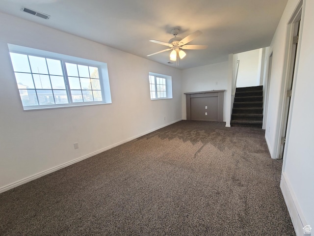 interior space with baseboards, visible vents, stairway, ceiling fan, and carpet floors