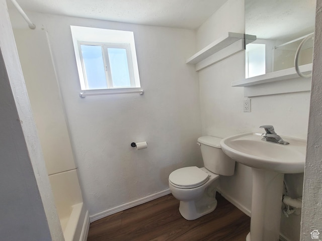full bathroom featuring wood finished floors, toilet, a sink, baseboards, and walk in shower