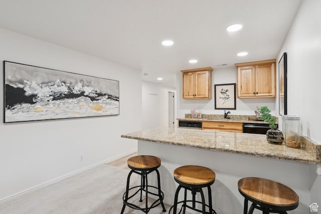 3041 Homestead Rd, Park City, UT 84098 - kitchen with a peninsula, recessed lighting, a kitchen bar, black dishwasher, and light stone counters