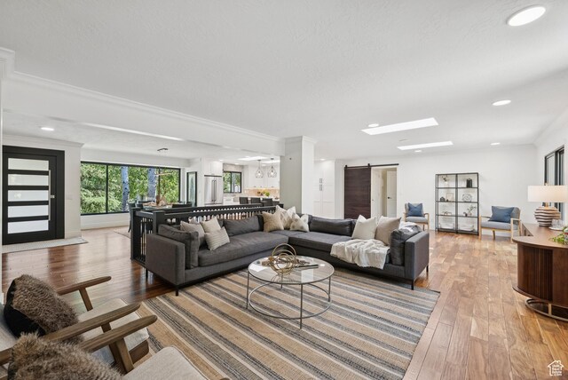 3041 Homestead Rd, Park City, UT 84098 - living room featuring a barn door, light wood-style flooring, recessed lighting, and ornamental molding