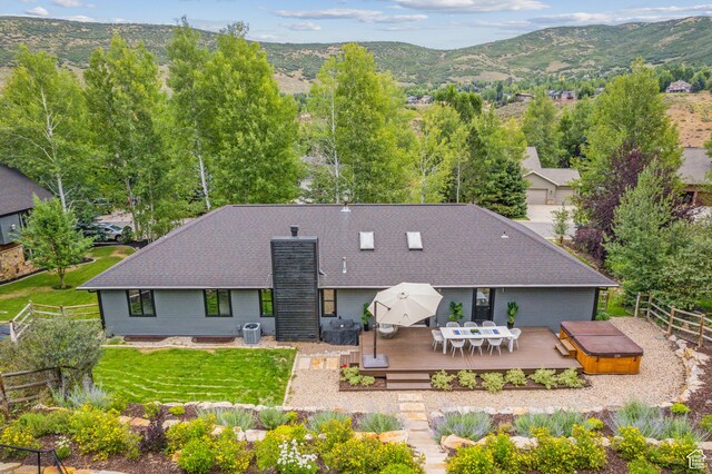 3041 Homestead Rd, Park City, UT 84098 - rear view of property featuring a deck with mountain view, a chimney, outdoor dining space, a hot tub, and roof with shingles