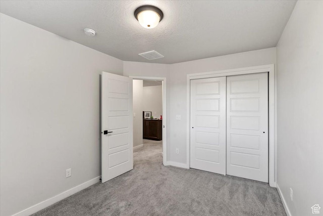 unfurnished bedroom with carpet, a closet, and baseboards