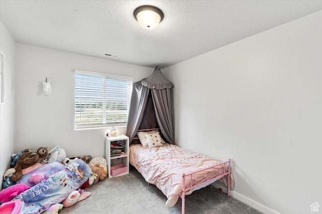 carpeted bedroom featuring a textured ceiling, baseboards, and visible vents
