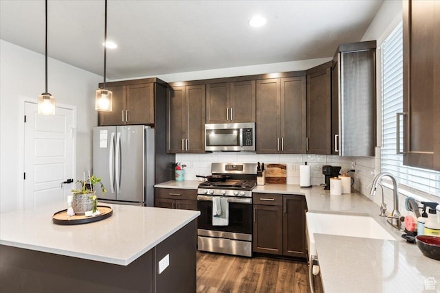 kitchen featuring dark brown cabinets, light countertops, a sink, stainless steel appliances, and decorative backsplash