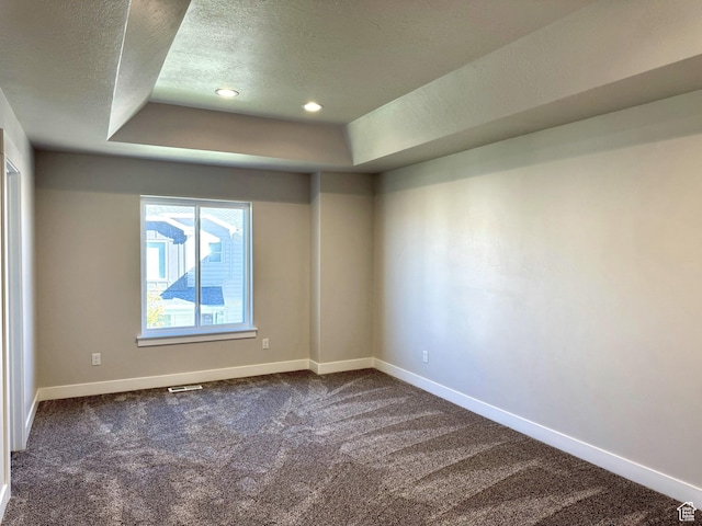 184 W Seasons Ln Unit 56, Garden City, UT 84028 - empty room featuring a tray ceiling, dark colored carpet, recessed lighting, baseboards, and a textured ceiling