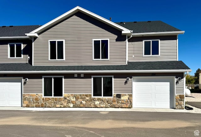 184 W Seasons Ln Unit 56, Garden City, UT 84028 - view of front facade featuring a shingled roof, stone siding, and a garage