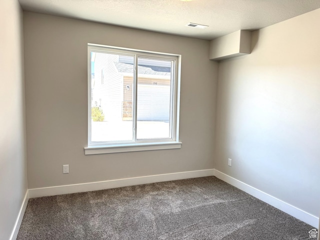 184 W Seasons Ln Unit 56, Garden City, UT 84028 - spare room with visible vents, baseboards, dark colored carpet, and a textured ceiling