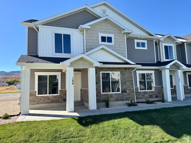 184 W Seasons Ln Unit 56, Garden City, UT 84028 - view of front of property featuring stone siding, a front lawn, and board and batten siding