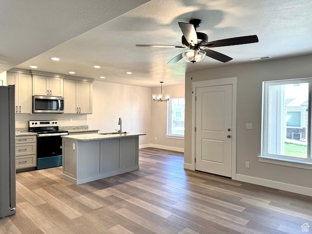 184 W Seasons Ln Unit 56, Garden City, UT 84028 - kitchen with a sink, light wood finished floors, appliances with stainless steel finishes, baseboards, and visible vents