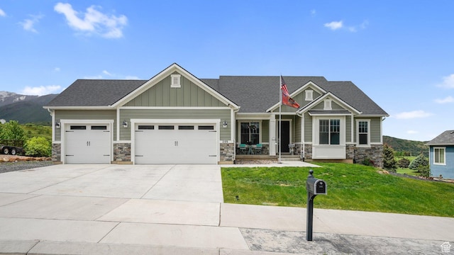 209 N Elk Ridge Dr, Elk Ridge, UT 84651 - craftsman inspired home with stone siding, an attached garage, a front lawn, covered porch, and concrete driveway