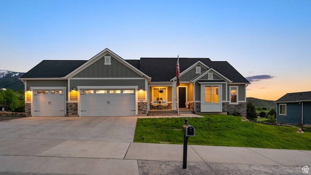 209 N Elk Ridge Dr, Elk Ridge, UT 84651 - craftsman inspired home with stone siding, an attached garage, a yard, driveway, and board and batten siding