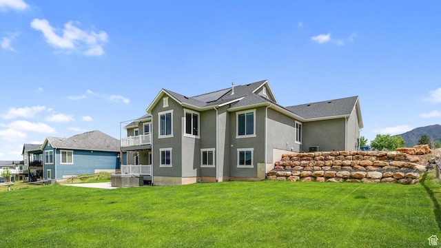 209 N Elk Ridge Dr, Elk Ridge, UT 84651 - back of property featuring solar panels, a yard, a hot tub, and stucco siding
