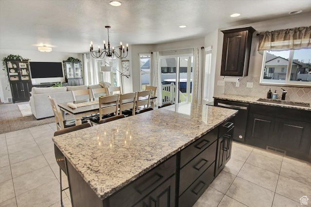 kitchen featuring a center island, a sink, visible vents, an inviting chandelier, and dishwasher