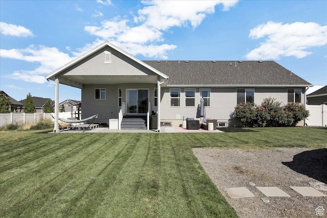 rear view of house with a patio, stucco siding, and fence
