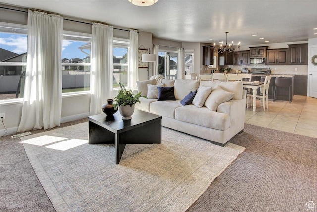 living area featuring recessed lighting, visible vents, light tile patterned flooring, light colored carpet, and a notable chandelier