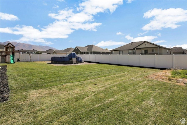 view of yard with a fenced backyard, a swimming pool, and a playground