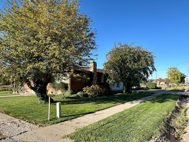 view of front of house featuring a front lawn and brick siding