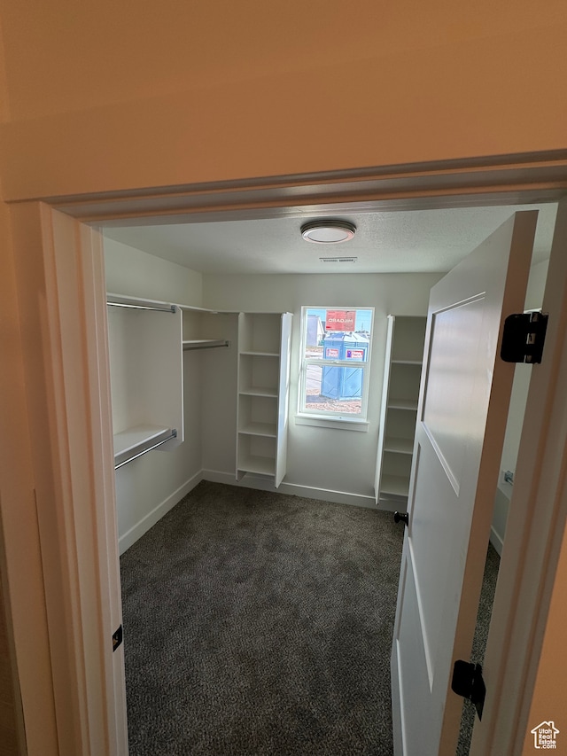 walk in closet with dark carpet and visible vents