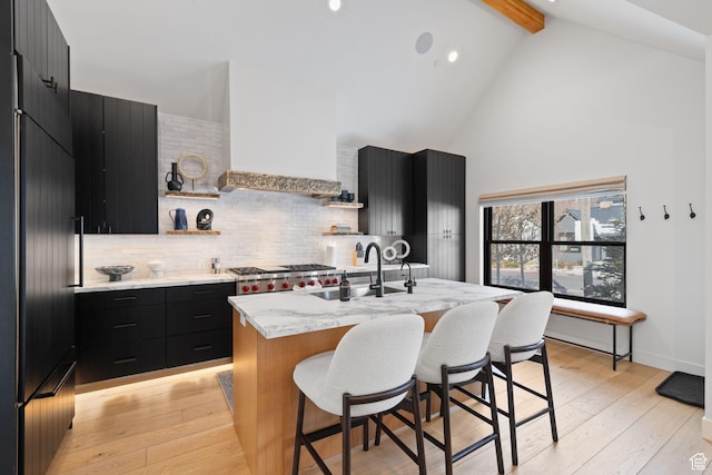 1125 Park Ave Unit 2, Park City, UT 84060 - kitchen featuring dark cabinetry, a sink, beamed ceiling, a breakfast bar, and high vaulted ceiling