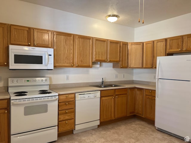 502 S 1040 E Unit 221, American Fork, UT 84003 - kitchen with a sink, brown cabinetry, light floors, white appliances, and light countertops