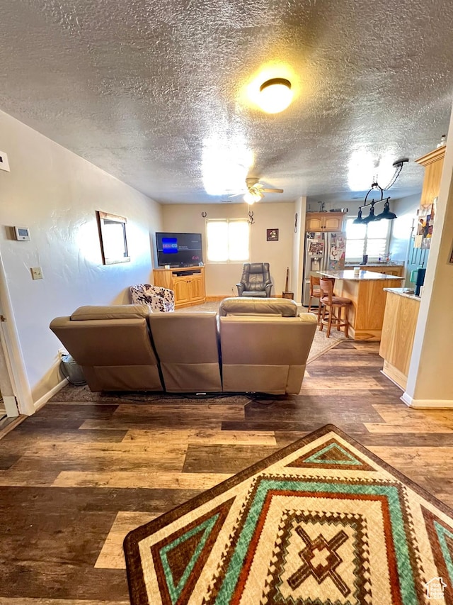 1942 N Sevier Valley Canal Rd, Richfield, UT 84701 - living area with a textured ceiling, wood finished floors, baseboards, and a ceiling fan