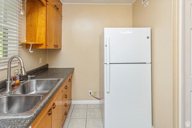 965 E 39th St S, South Ogden, UT 84403 - kitchen featuring freestanding refrigerator, a sink, dark countertops, light tile patterned floors, and brown cabinetry