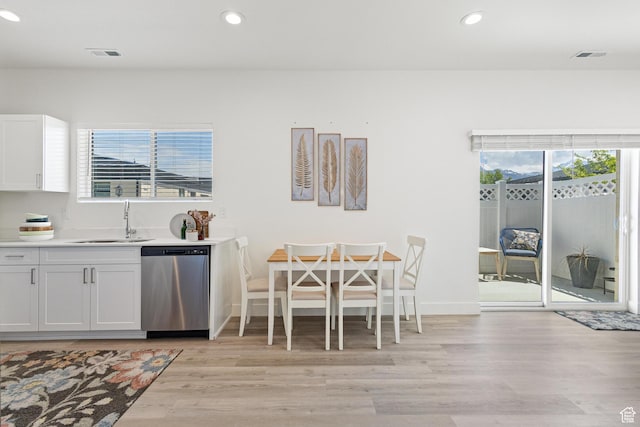 kitchen with a sink, a healthy amount of sunlight, visible vents, and dishwasher
