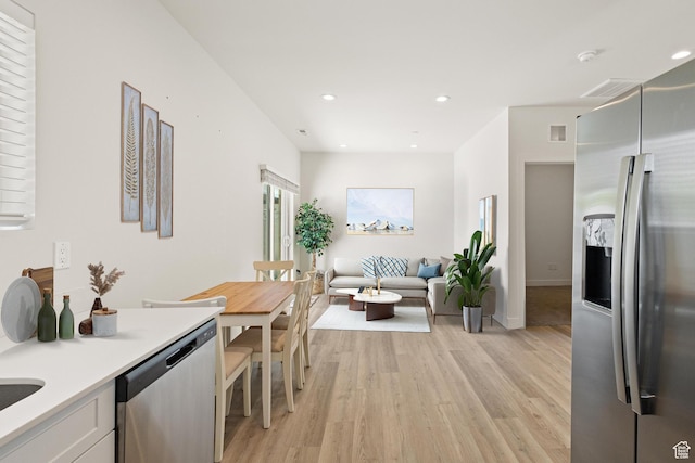kitchen featuring white cabinets, light wood-style floors, light countertops, stainless steel appliances, and visible vents