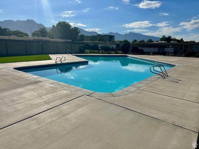 view of swimming pool featuring a fenced in pool, a patio area, a mountain view, and fence