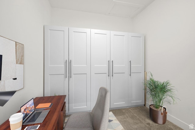 carpeted home office featuring attic access
