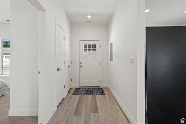 doorway to outside featuring recessed lighting, baseboards, light wood-type flooring, visible vents, and electric panel