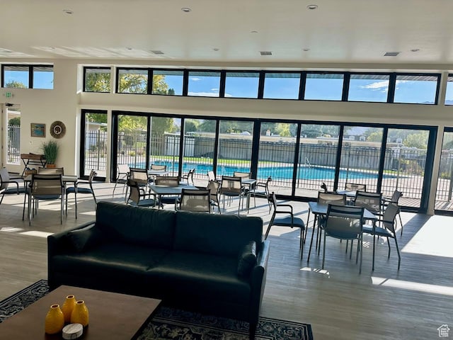 living area featuring visible vents, a high ceiling, and wood finished floors