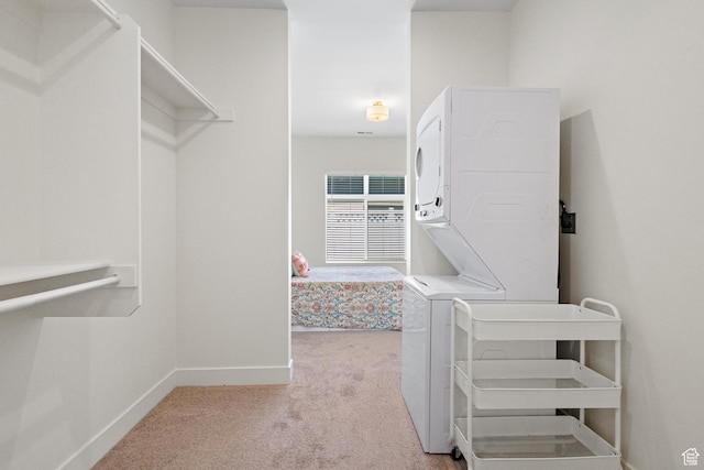 walk in closet featuring carpet flooring and stacked washer and dryer