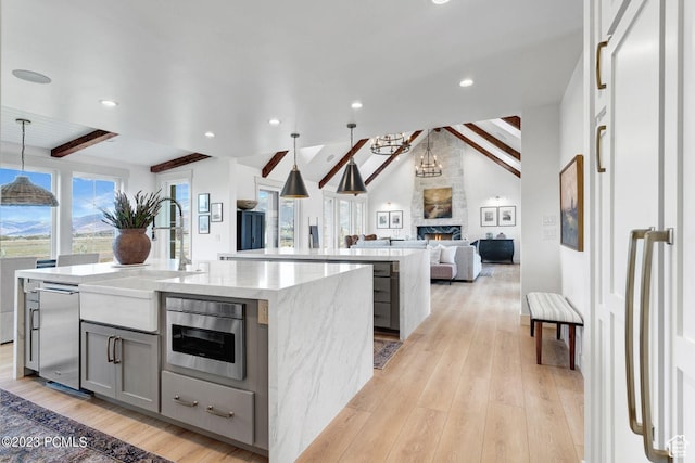 937 Hart Loop, Kamas, UT 84036 - kitchen with hanging light fixtures, gray cabinetry, lofted ceiling with beams, an island with sink, and light wood-type flooring
