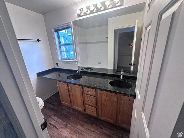 1988 E Gregson Ave, Millcreek, UT 84106 - bathroom featuring double vanity, wood finished floors, toilet, and a shower