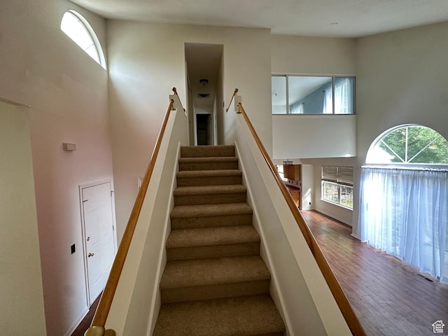 1988 E Gregson Ave, Millcreek, UT 84106 - stairway with a towering ceiling, healthy amount of natural light, and wood finished floors