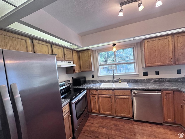 1988 E Gregson Ave, Millcreek, UT 84106 - kitchen featuring appliances with stainless steel finishes, a sink, under cabinet range hood, and dark countertops