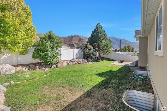view of yard featuring a mountain view, a fenced backyard, and a patio area