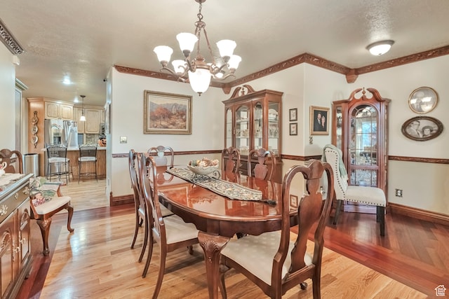 1040 E Canyon Rd, Hyde Park, UT 84318 - dining space featuring a textured ceiling, light wood-type flooring, and a chandelier