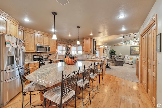 1040 E Canyon Rd, Hyde Park, UT 84318 - kitchen featuring appliances with stainless steel finishes, tasteful backsplash, light wood-type flooring, lofted ceiling, and decorative light fixtures