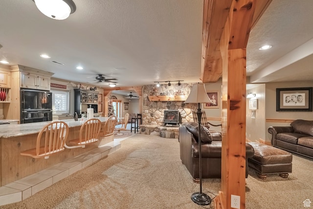 1040 E Canyon Rd, Hyde Park, UT 84318 - living room featuring a textured ceiling, a fireplace, ceiling fan, and light colored carpet