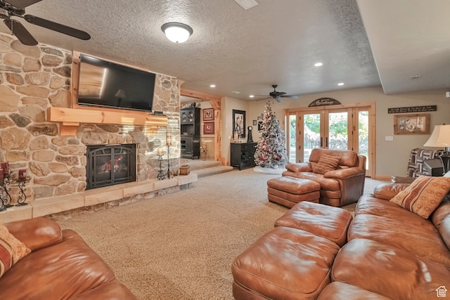 1040 E Canyon Rd, Hyde Park, UT 84318 - living room with a textured ceiling, carpet, a stone fireplace, ceiling fan, and french doors